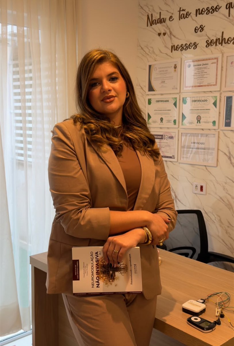 Letícia Ribeiro com o livro Neuromodulação Não Invasiva, do qual é coautora